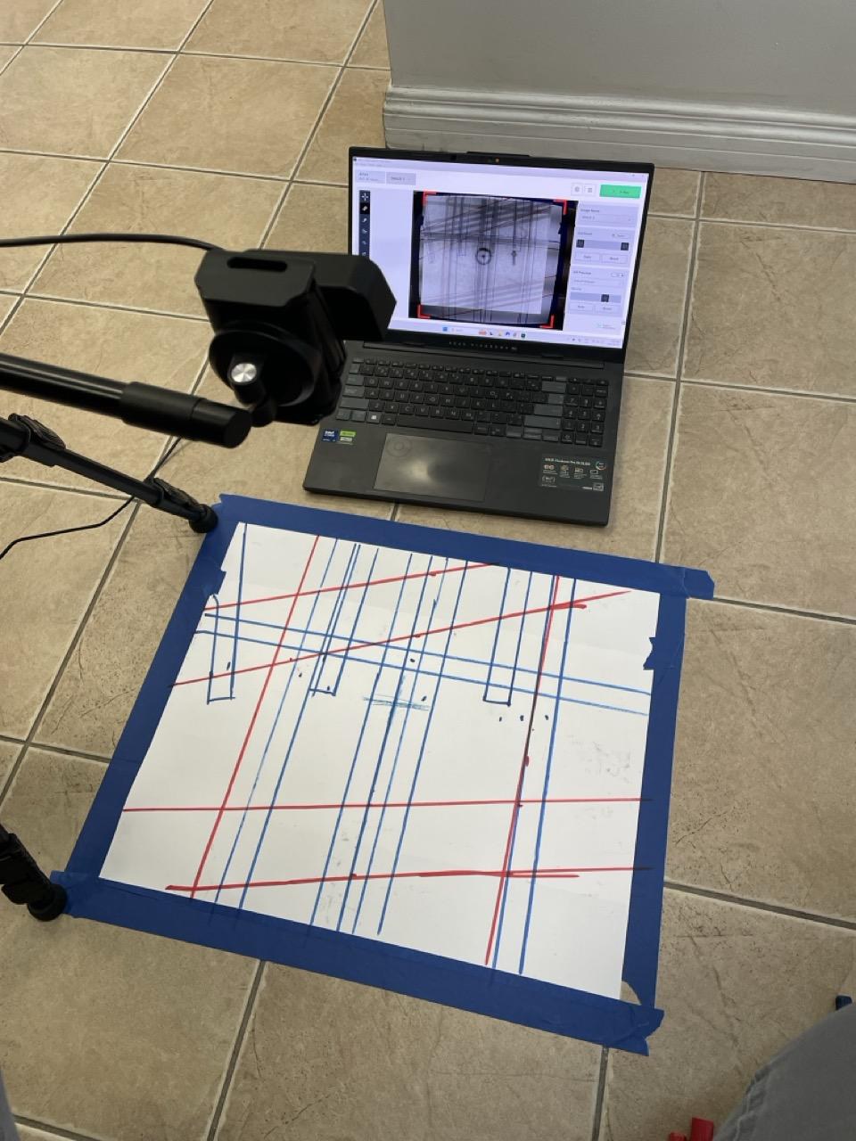 The result of marking with AR Preview: a slab fully marked with rebar in blue, PT cables and conduits in red, with the laptop still running the AR overlay in the background — clean lines, nothing missed