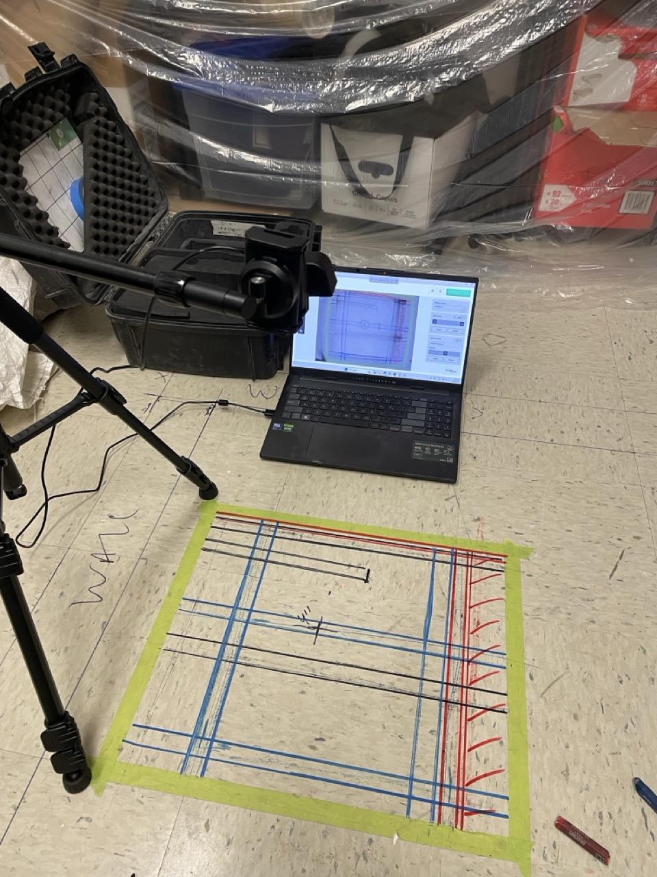 An early AR Preview test: a tripod-mounted webcam pointed at a colour-coded grid of rebar and PT cable marks taped on the floor, with the laptop running Radii-x software showing the overlay alignment