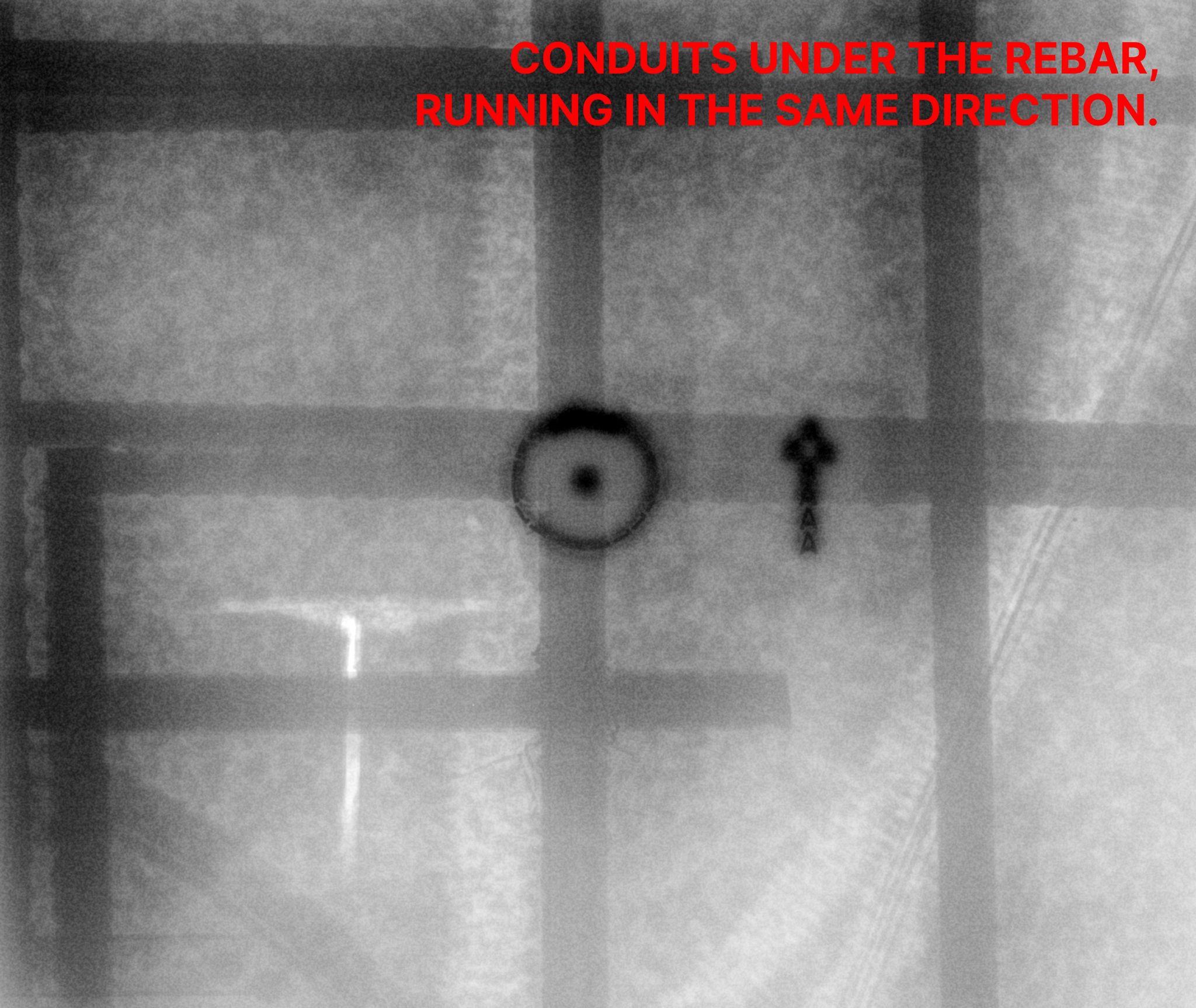 Digital concrete X-Ray radiograph revealing conduits running directly under the rebar in the same direction — the layering that buries a conduit's reflection under the rebar signal on a GPR scan